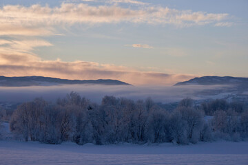 Fototapeta na wymiar View of the Totenåsen Hills, Norway, seen from the rural lowlands in winter.