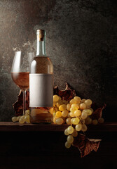 Wine with grapes and dried up vine leaves.