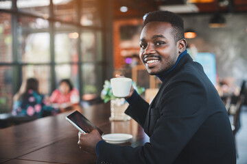 African businessman using tablet computer in coffee shop