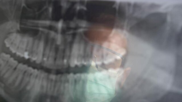 Panoramic Dental X-Ray Image Examined by Dentist in Surgical Mask and Glasses