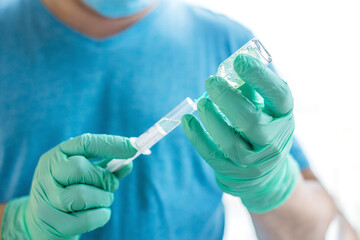 Hands of the doctor filling a syringe with vaccine. medicine, vaccination and drug concept....