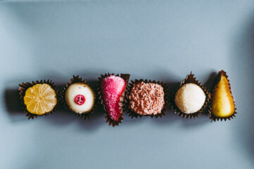 Friandises dans une assiette grise avec des - Assortiment de chocolats pâtes de fruits et fruits...