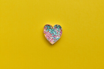 Composition for Valentine's Day February 14th. Delicate yellow background and pink hearts cut out of paper. Greeting card. Flat lay, top view, copy space.