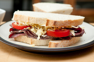 sliced roast beef sandwich, cheese and tomato and cole slaw