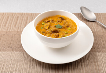 creamy peas and mushroom curry in a white bowl