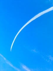 弧を描く飛行機雲
