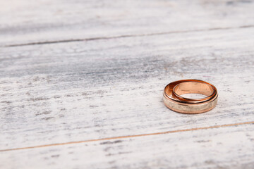 One golden ring on white wood. Shiny jewelry wedding ring.