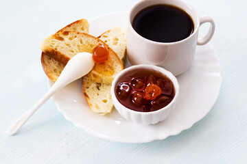 Breakfast. Fresh bread with jam and black coffee on a light background. Traditional breakfast. Healthy food concept. Flat layout.