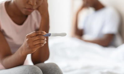 Obraz na płótnie Canvas Unrecognizable black woman holding pregnancy test, unintended pregnancy concept