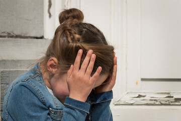 Image of a young exasperated girl with her head in her hands.