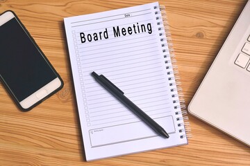 Board Meeting label on notepad with laptop and smartphone