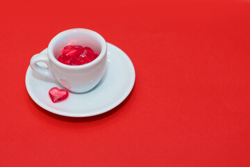 cup with hearts on a red background. the view from the top. red hearts spilled out. isolated on a pink background. copy space