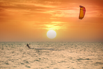 Kitesurfer during a sunrise session in the early morning. Kitesuring in the morning