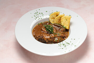 Homemade stew of osso buco meat with aromatic herb sauce