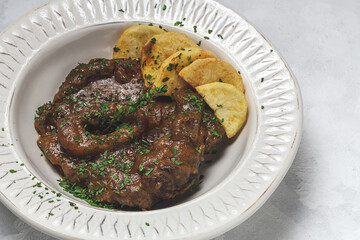 Homemade stew of osso buco meat with aromatic herb sauce