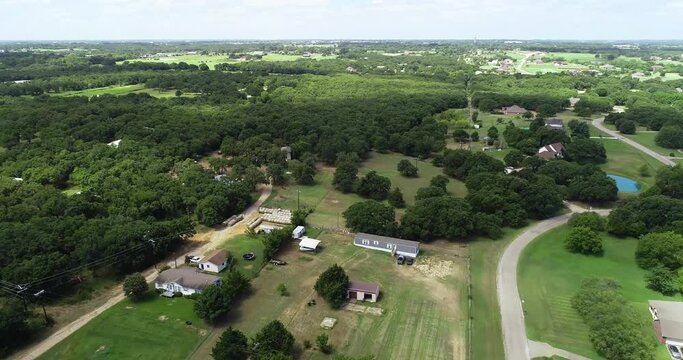 Aerial flight over the city of Sanger in Texas.  Houses, ponds and countryside are visible.