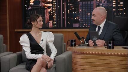 Late-night talk show host having a conversation with celebrity guest in a studio. TV broadcast...