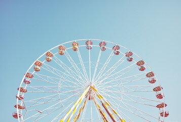 Picture of a Ferris wheel against the blue sky, retro colors toning applied.