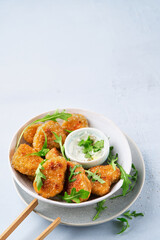 Vegetarian Nuggets with Vegan Dipping Sauce and rocket leaves on a light background with copy space, selective focus. Healthy Diet, Protein Vegetarian Meals concept, alternative meat products.