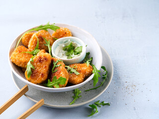 Vegetarian Nuggets with Vegan Dipping Sauce and rocket leaves on a light background with copy space, selective focus. Healthy Diet, Protein Vegetarian Meals concept, alternative meat products.