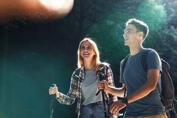 Young couple hiking in nature.They walking trough forest on beautiful sunset.	
