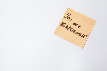 You are enough text written on yellow sticky note