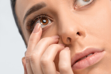 One woman holds contact lens on her finger. Eye care and the choice between the means to improve...