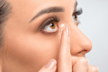 One woman holds contact lens on her finger. Eye care and the choice between the means to improve...