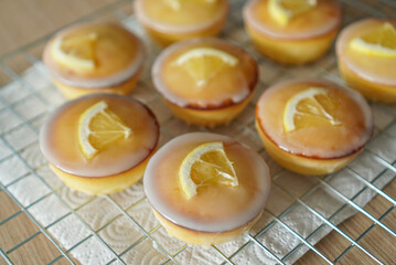 Moist and Sweet Lemon Butter Cake flavored with Lemon Juice Glaze Icing and Zest, garnished with a lemon slice. Soft and Sour Cream Lemon Dessert, putting on a steel baking rack.