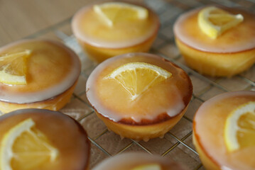 Moist and Sweet Lemon Butter Cake flavored with Lemon Juice Glaze Icing and Zest, garnished with a lemon slice. Soft and Sour Cream Lemon Dessert, putting on a steel baking rack.