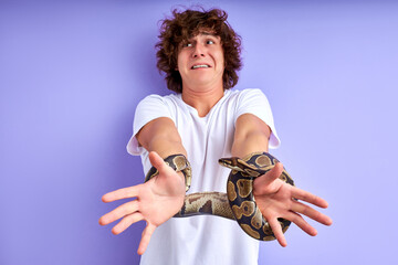 snake tied man's hands. guy stand crying by fear, thinks how to get free from the shackles of the snake