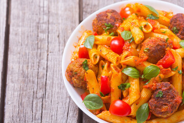 Italian penne pasta with meatballs and tomatoes