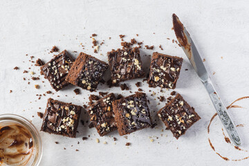 Chocolate brownie squares with knife, grey background, top view, horisontal orientation. Flat lay...