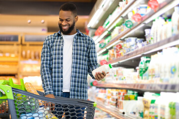 Cheerful Black Guy Doing Shopping Buying Groceries In Supermarket