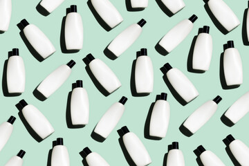 Pattern of the cosmetic bottles on the turquoise background. Cosmetics flat lay. copy space