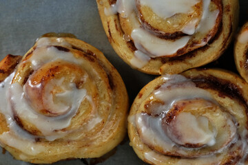 Close up of cinnamon rolls for sweet pastry breakfast food with icing from top view.