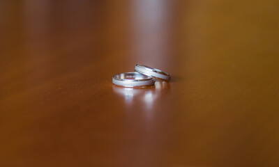 shiny silver wedding rings on wooden table