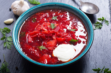 Homemade bowl with borscht and herbs