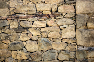 Old stone wall, dry construction. Spring street partial view, town of Metsovo, Epirus, Greece. The establishment is popular winter ski Greek resort with old Balkans style houses. Background, wallpaper