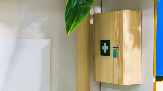 Wood first aid kit box on on a white wall in interiors