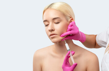 Cosmetologist makes lipolytic injections to burn fat on the chin, cheeks and neck of a woman...