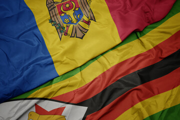waving colorful flag of zimbabwe and national flag of moldova.