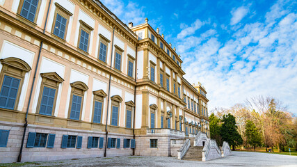 Fototapeta na wymiar Facade of the elegant Villa Reale in Monza, Italy. Blue sky and white clouds in the background. Villa Reale translation: Royal Villa