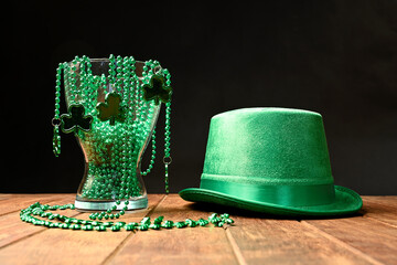 Concept of St. Patrick. Green hat and necklaces on a black background.