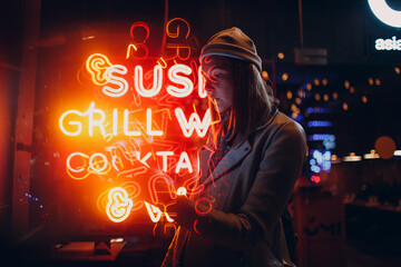 Young asian millennials woman in street style fashion in neon light lettering signboard