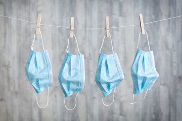 Mund Nasen Schutz an einer W&auml;scheleine vor einem Holzhintergrund