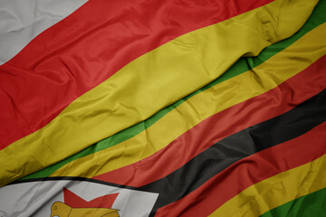 waving colorful flag of zimbabwe and national flag of south ossetia.