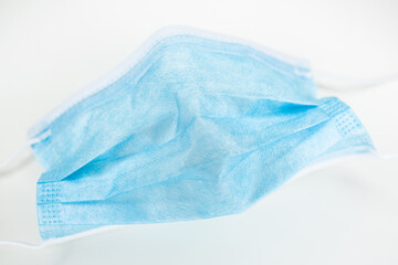 ein verwendeter Mund Nasen Schutz zu Corona Zeiten auf wei&szlig;em Untergrund