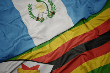 waving colorful flag of zimbabwe and national flag of guatemala.