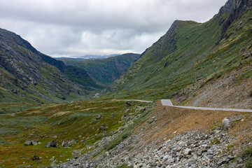 Fototapeta na wymiar Picturesque road in the valley between mountains in Norwegian countryside